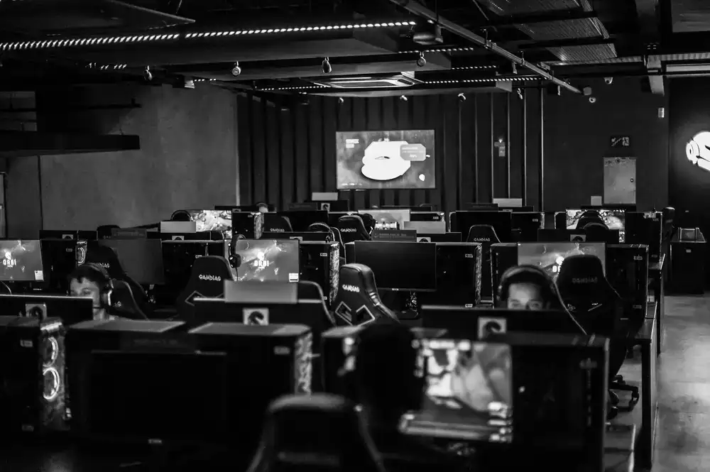 Gamers sitting at high-end PC setups in the illuminated LAN arena